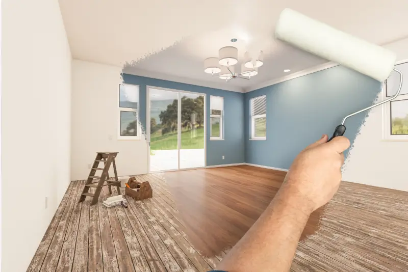 Painter rolling a soft blue accent wall, one of many interior paint colors for Miami homes